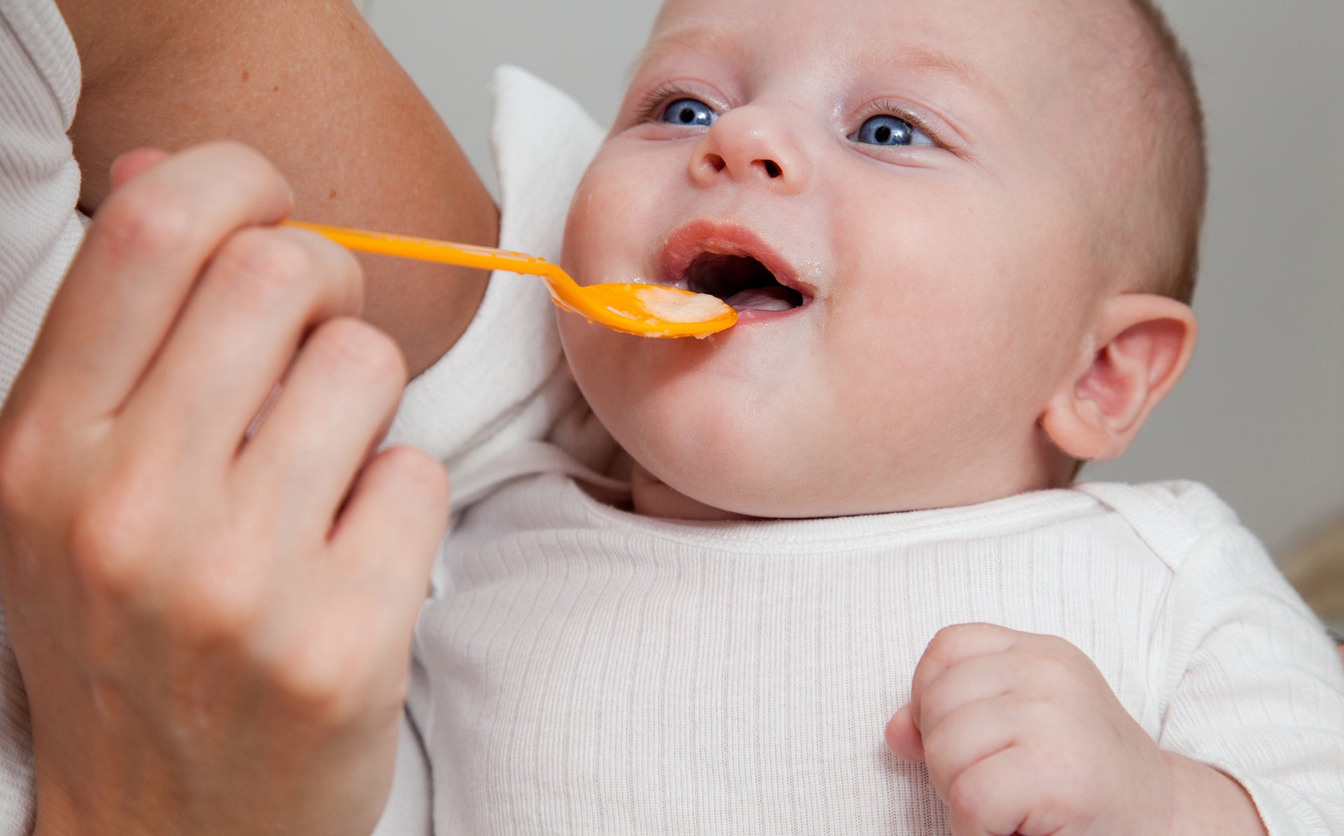 Dziecko probujace jesc pokarm z lyzeczki